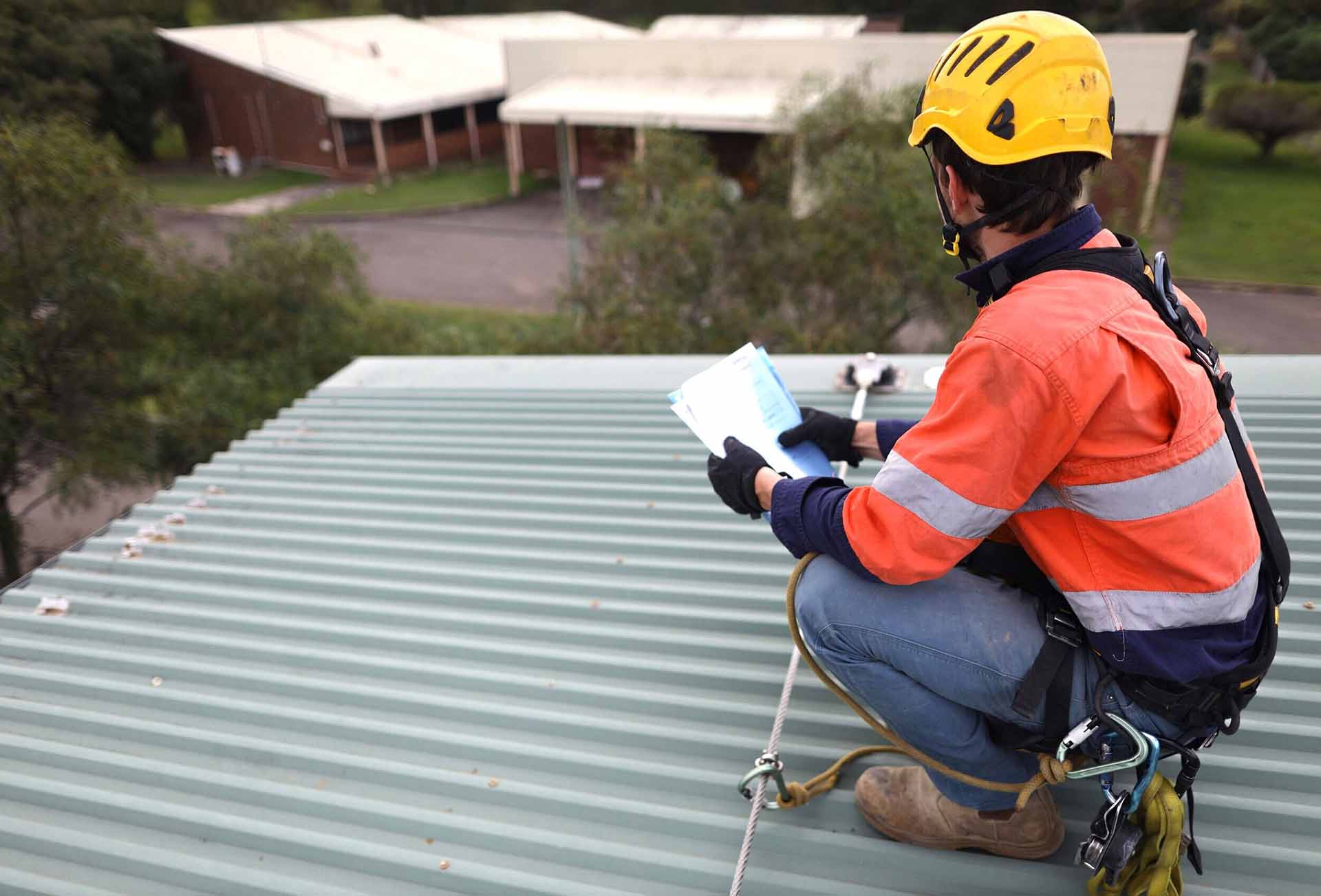Professional roofer with hardhat and harness