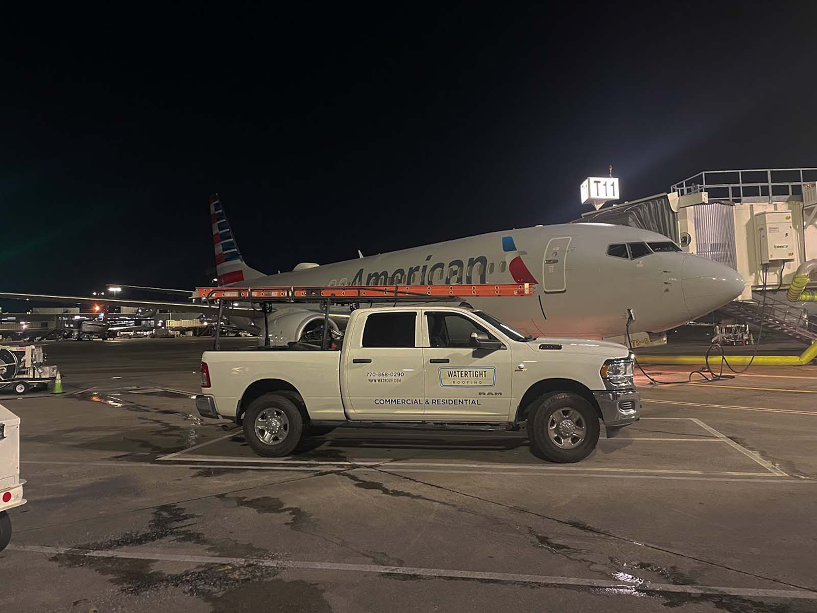Watertight Roofing service vehicle working near an aircraft at night