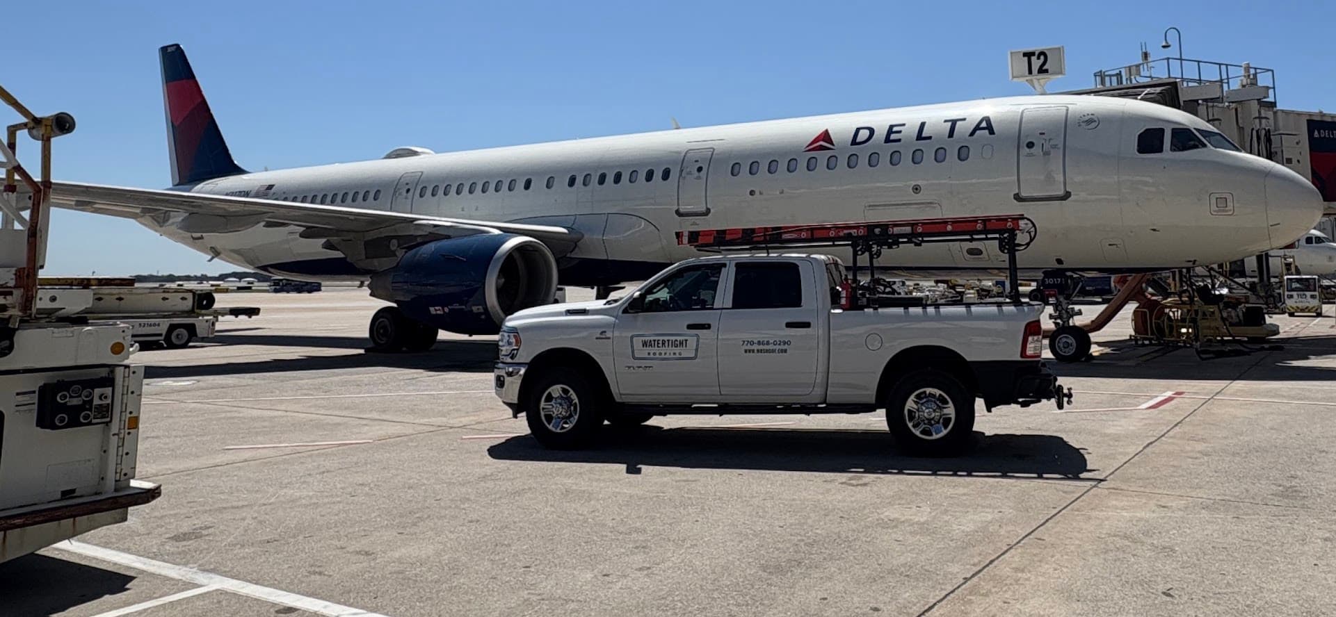 Watertight Roofing work truck in front of a Delta Airlines airplane