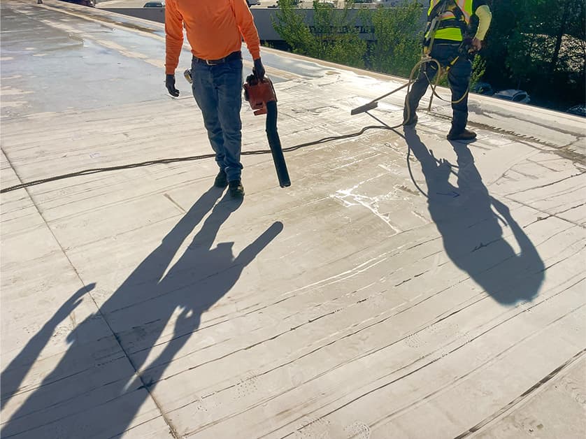Commercial roofing professionals performing preventative roof maintenance